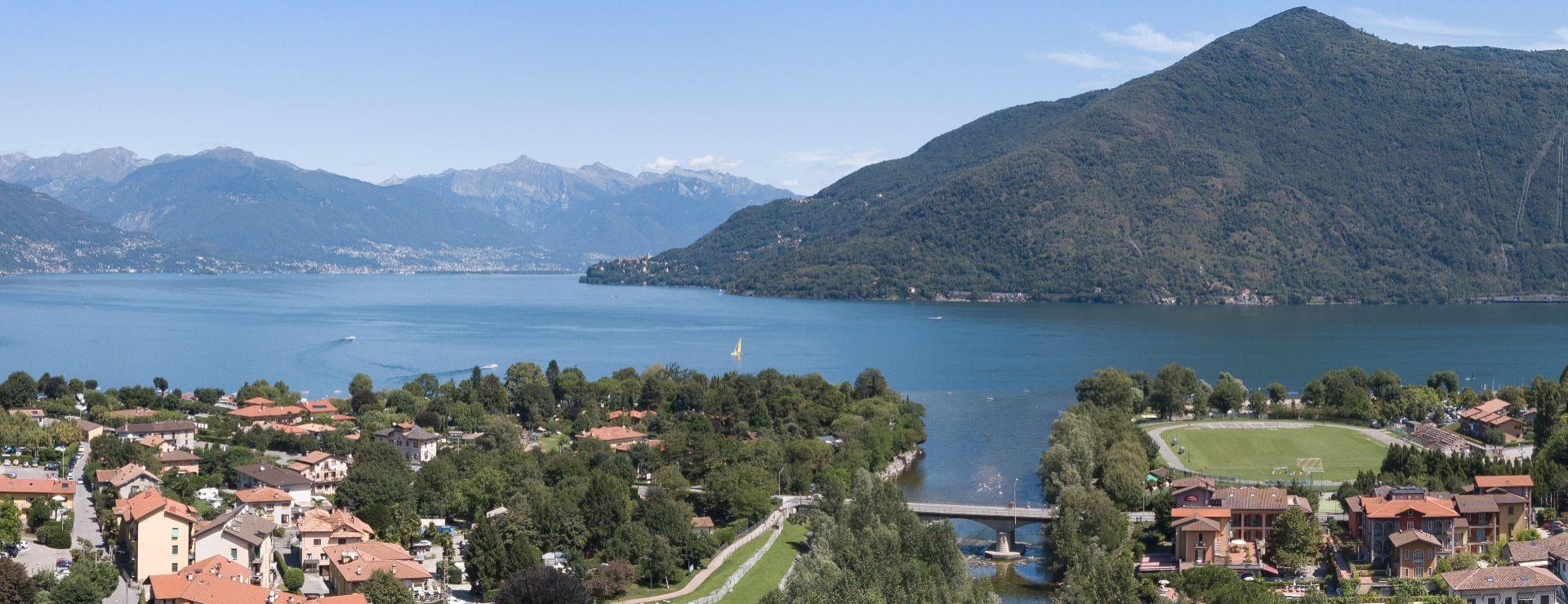 Vista panoramica di un lago con montagne e villaggio pittoresco.